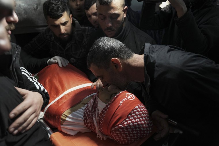 Los dolientes se reúnen alrededor del cuerpo de Amr Khamour, un palestino de 14 años, durante su funeral en Belén, Cisjordania, el 16 de enero.