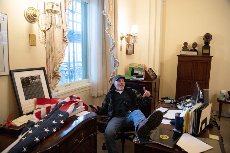 Richard Barnett, a supporter of US President Donald Trump sits inside the office of US Speaker of the House Nancy Pelosi as he protest inside the US Capitol in Washington, DC, January 6, 2021. - Demonstrators breeched security and entered the Capitol as Congress debated the a 2020 presidential election Electoral Vote Certification.