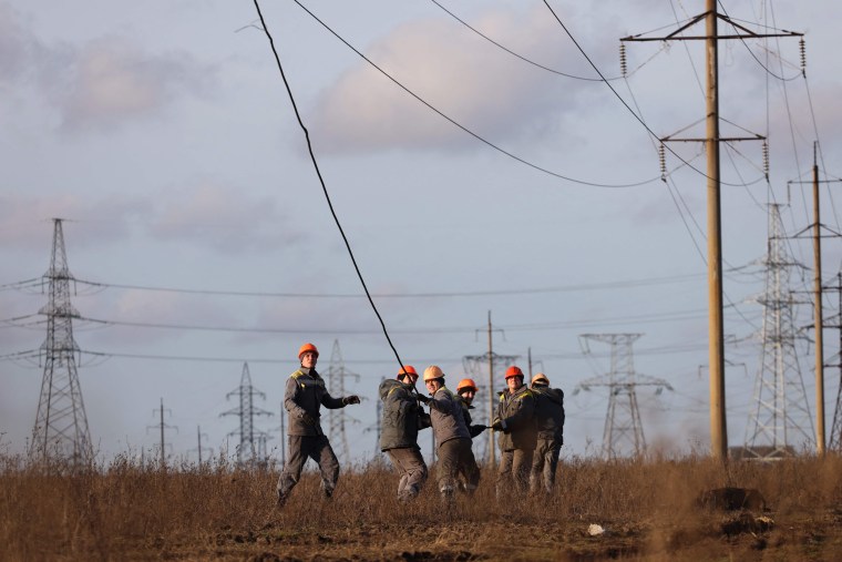 Workers repair high-voltage power lines damaged by recent missile strikes near Odessa, Ukraine, on Dec. 29, 2022.