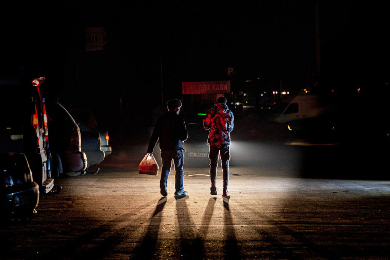 People walk in Kramatorsk, eastern Ukraine, during a power outage on Dec. 24, 2022. 