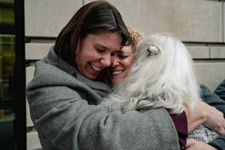 Nicole Enfield, left, hugs Emily Paterson and Rolande Baker on Jan. 13, 2023 after they got probation for disrupting a Supreme Court hearing.