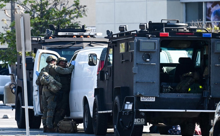 Law enforcement officers open the door of a van in Torrance, California where a suspected suspect in the mass shooting that killed 10 people in Monterey Park on January 22, 2023 is believed to be hiding.