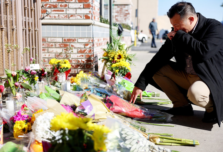 Monterey Park mayor Henry Lo kneels at a makeshift memorial outside the scene of a deadly mass shooting at a ballroom dance studio, in Monterey Park, Calif., on Jan. 23, 2023.