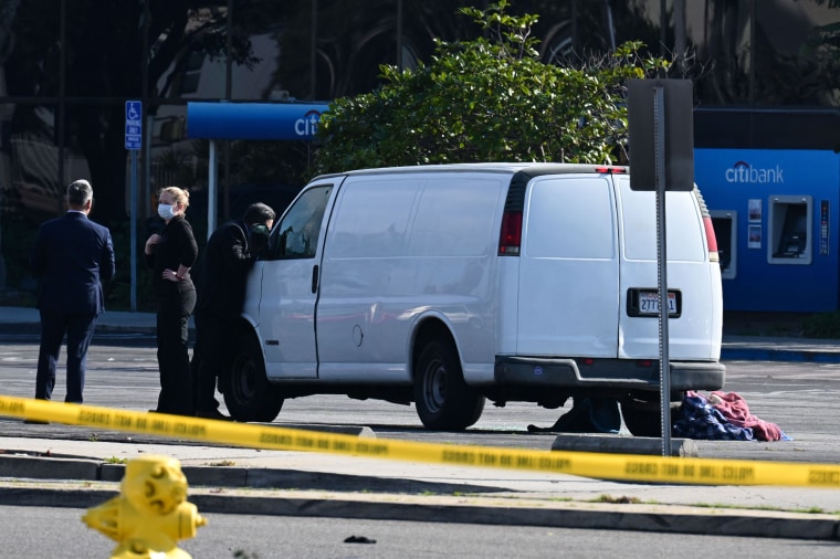 Officers peer into the window of a van believed to have a body in the driver's seat in Torrance