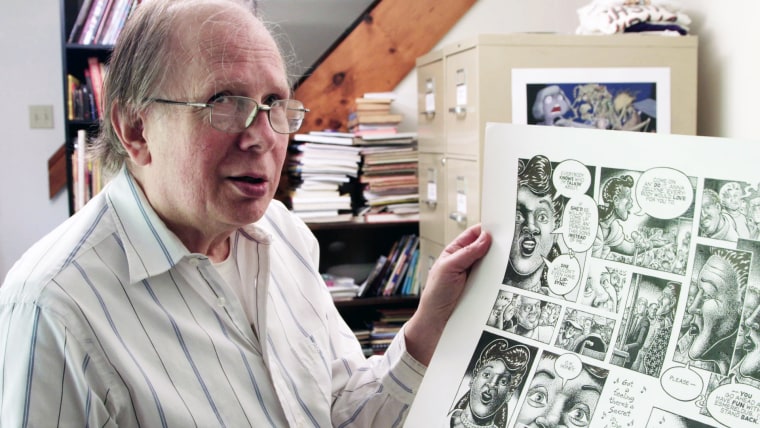Howard Cruse holding a comic page.