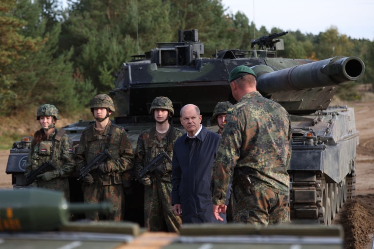 German Chancellor Olaf Scholz in front of a Leopard 2 battle tank during a visit to a military base in Ostenholz, Germany, on Oct. 17, 2022.