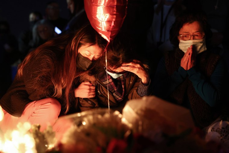 People gather at a candlelight vigil for victims of a mass shooting at a ballroom dance studio in Monterey Park, Calif.