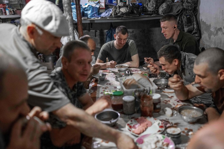 Ukrainian soldiers eat lunch together at a base close to the frontline in the south of the country on Aug. 20, 2022.
