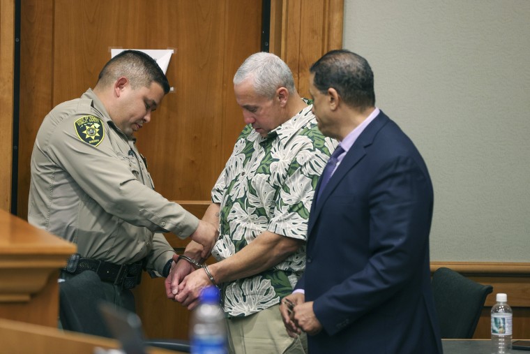 A court officer removes Albert Schweitzer's handcuffs at a hearing in Hilo, Hawaii
