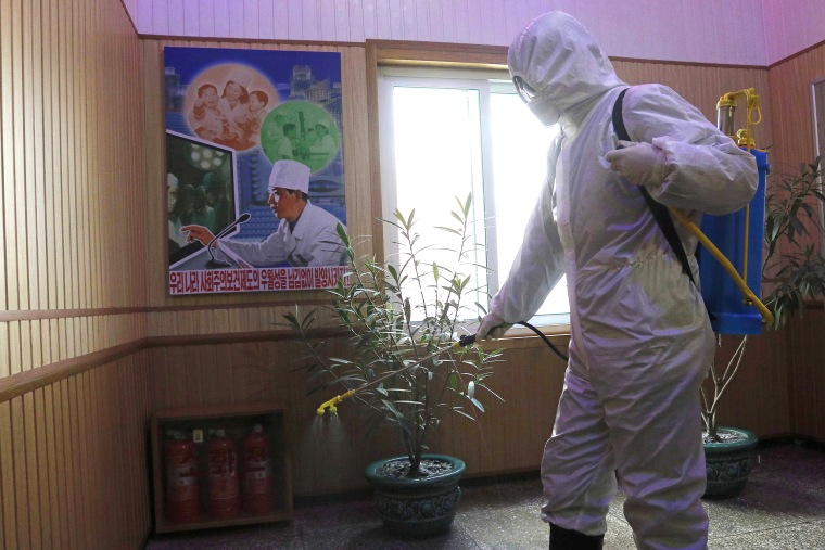 FILE- An official of the Hygienic and Anti-epidemic Center in Phyongchon District disinfect the corridor of a building in Pyongyang, North Korea, on Feb. 5, 2021. The Korean Central News Agency said Thursday, May 12, 2022, tests from an unspecified number of people in the capital Pyongyang confirmed that they were infected with the omicron variant.