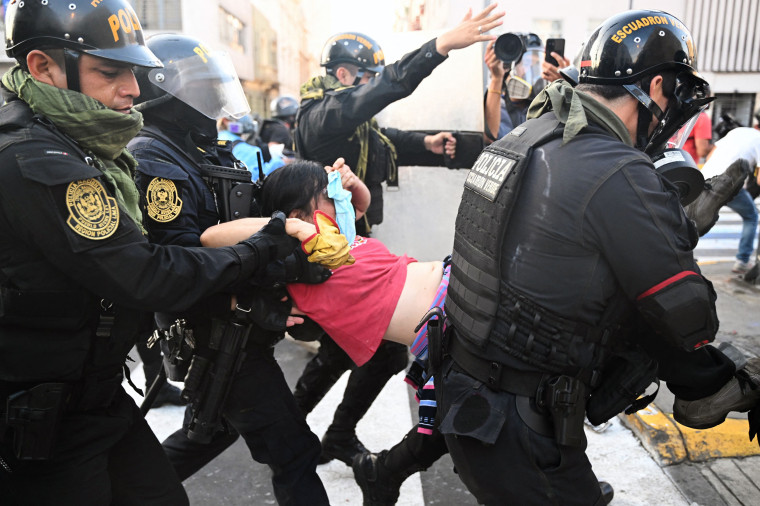 Riot police carry a demonstrator affected by tear gas during a protest against President Dina Boluarte's government in Lima, Peru