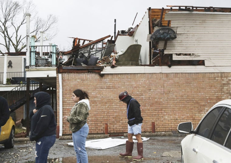 Residents walk past their damaged apartment complex after a storm system swept through Deer Park, Texas