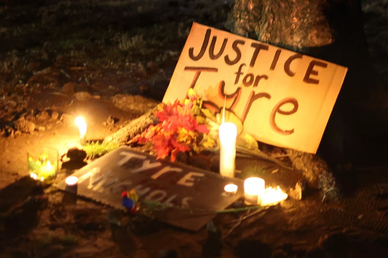 A sign that says "Justice for Tyre" surrounded by flowers and candles.