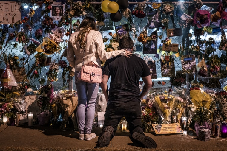 Mourners visit a memorial to those lost in a shooting at a King Soopers grocery store on March 27, 2021, in Boulder, Colo.