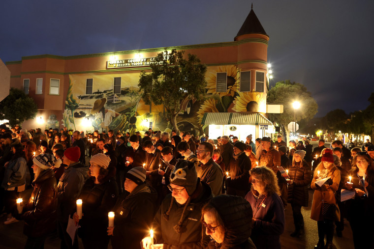 Mourners hold candles during a candlelight vigil for the victims of the recent mass shooting in Half Moon Bay. Calif.