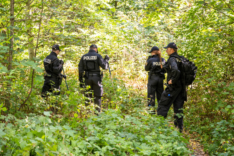 Police search a wooded area for clues and objects near where a female body was discovered in a passenger car on Aug. 17, 2022, in Bavaria, Ingolstadt, Germany.