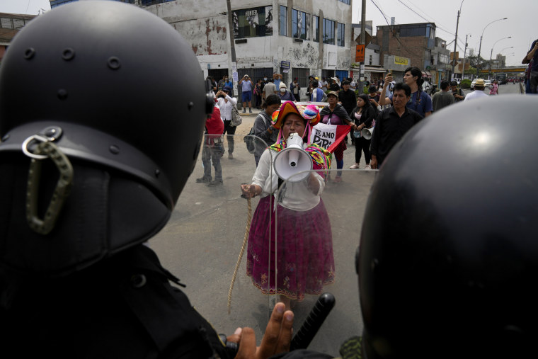 An anti-government protester challenges police surrounding San Marcos University in Lima, Peru, on Jan. 21, 2023. Image: