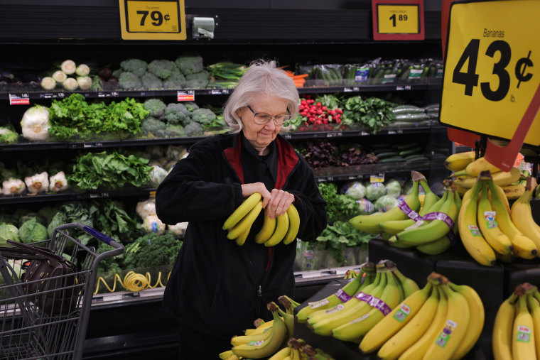 Pauline Doty picks bananas to add to the ones in her cart at a Food Lion in Columbia, SC., on Jan. 27, 2023.