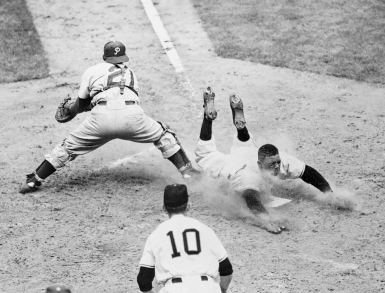 Willie Mays slides safely into the plate on Wes Westrum's base in the sixth inning of the game against the Philadelphia Phillies at the Polo Grounds, New York.