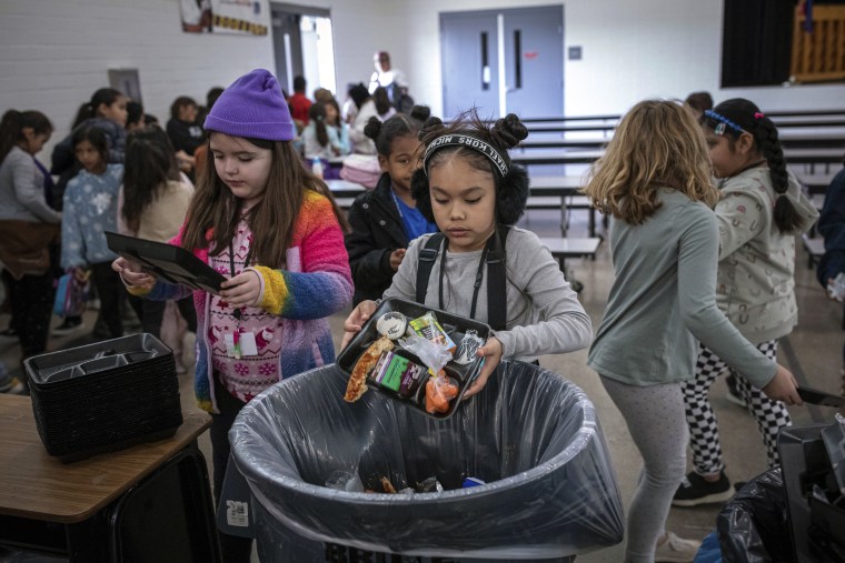 Estudiantes echan a la basura su almuerzo sin terminar, en la Escuela Primaria Yavapai en Scottsdale, Arizona, el 12 de diciembre de 2022. 