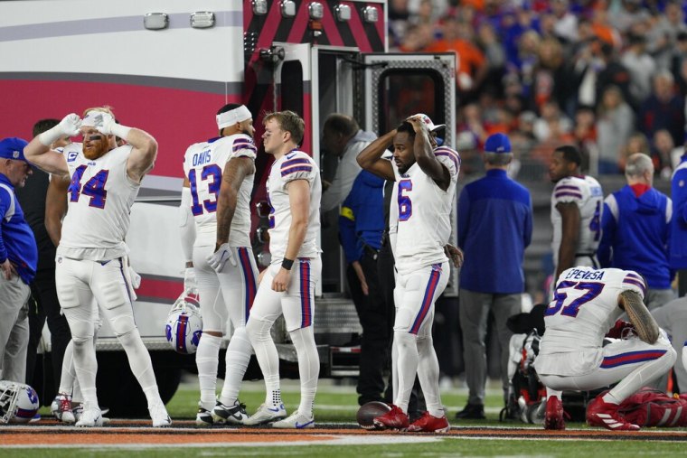 Jugadores de los Bills de Búfalo reaccionan mientras se llevan a su compañero Damar Hamlin en ambulancia tras colapsar en el encuentro ante los Bengals de Cincinnati el lunes 2 de enero del 2023.