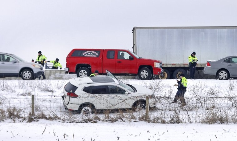 Personal de emergencias asiste a los afectados en una colisión múltiple ocurrida en medio de condiciones de nieve en la carretera interestatal 39/90 en Turtle, Wisconsin, el viernes 27 de enero de 2023.