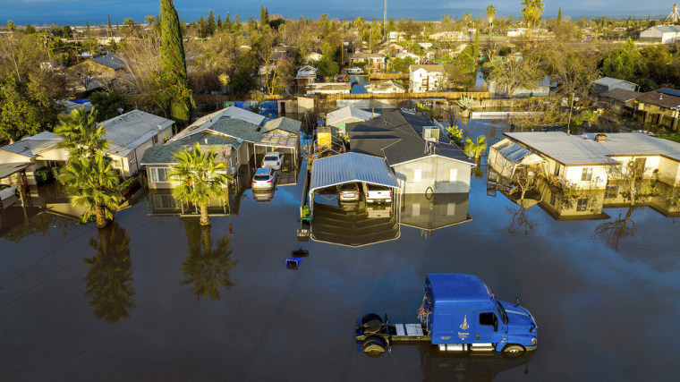 Tras varios días de lluvia, el agua rodea casas y vehículos en la comunidad de Planada, en el condado de Merced.