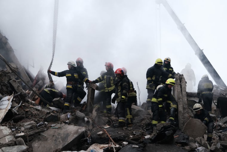 Trabajadores de emergencias registran los restos de un edificio residencial que fue alcanzado por un misil ruso ayer 15 de enero de 2023 en Dnipro, Ucrania.