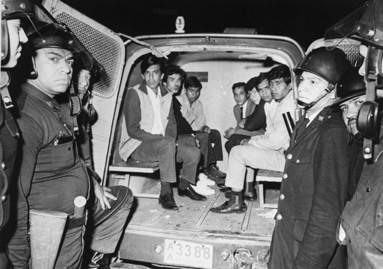 Siete jóvenes mexicanos están detenidos en una camioneta rodeada por seis policías en equipo antimotines el 3 de octubre de 1968 cerca de Tlatelolco, Ciudad de México