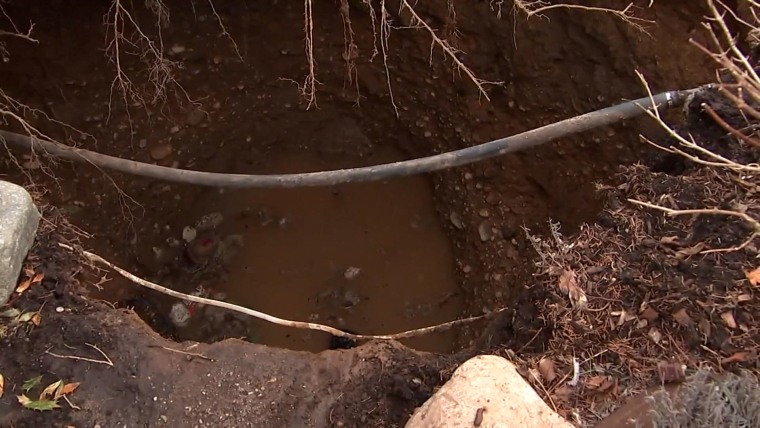 A hole in the ground partially filled with water