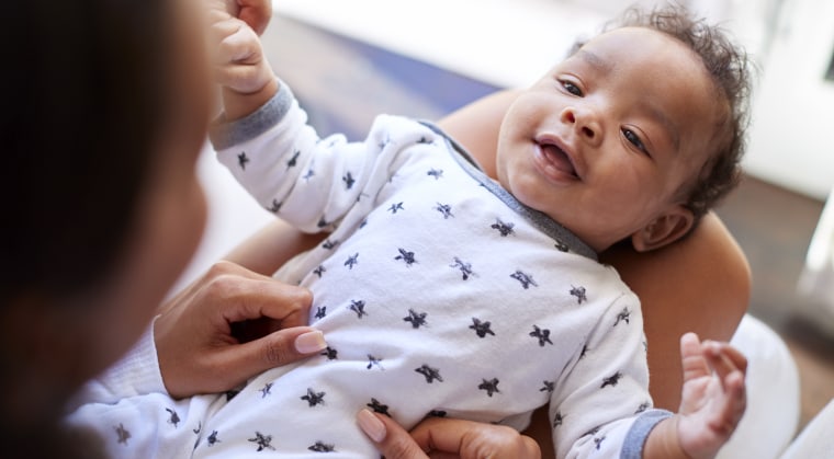 Happy three month old baby boy lying on his back on his back.