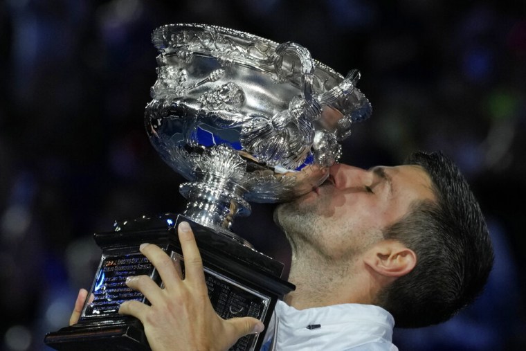 Novak Djokovic besa el trofeo de campeón del Abierto de Australia tras derrotar a Stefanos Tsitsipas en la final, este domingo 29 de enero en Melbourne.