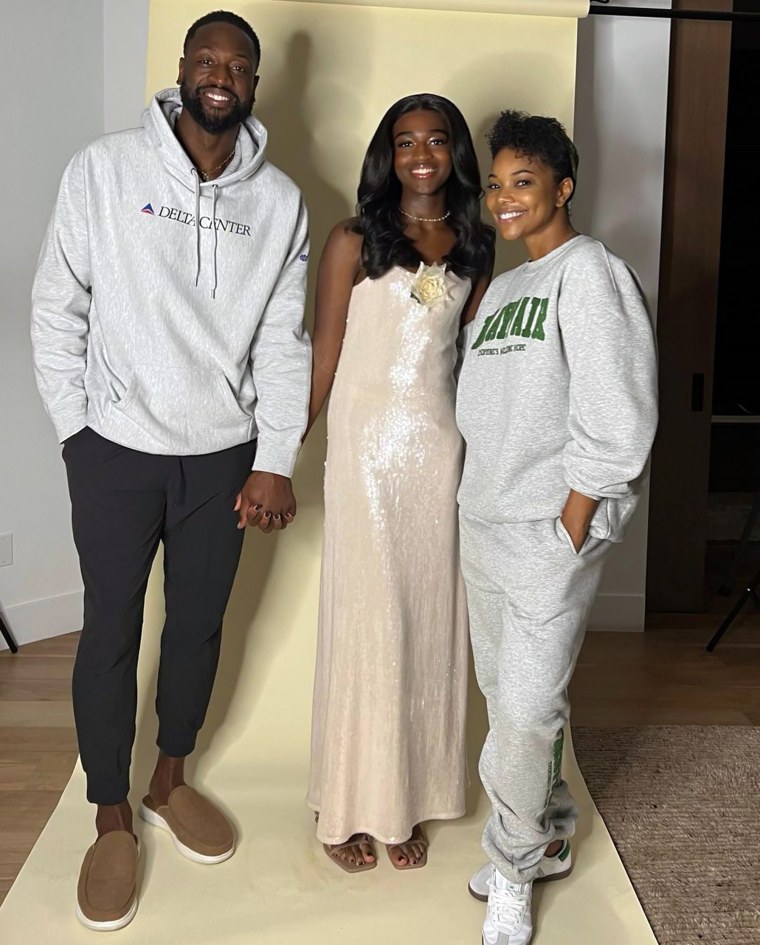 Dwayne Wade stands beside Zaya Wade and Gabrielle Union for a formal photo.