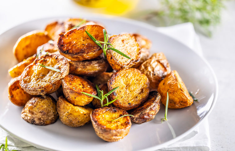 Golden baked potatoes with rosemary.