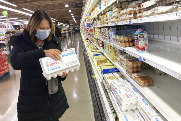 Una compradora revisa los huevos antes de comprarlos en una tienda de comestibles en Glenview, Illinois, el martes 10 de enero de 2023.