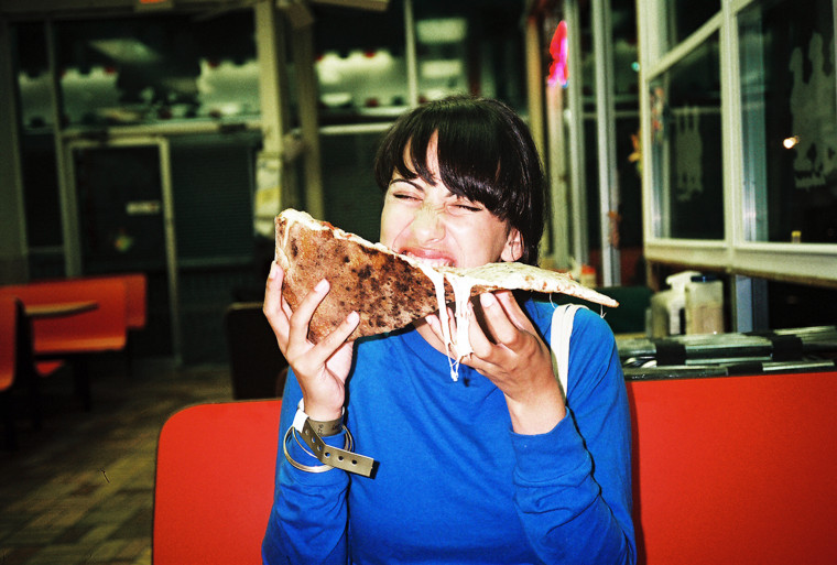 Woman eating a large piece of pizza.