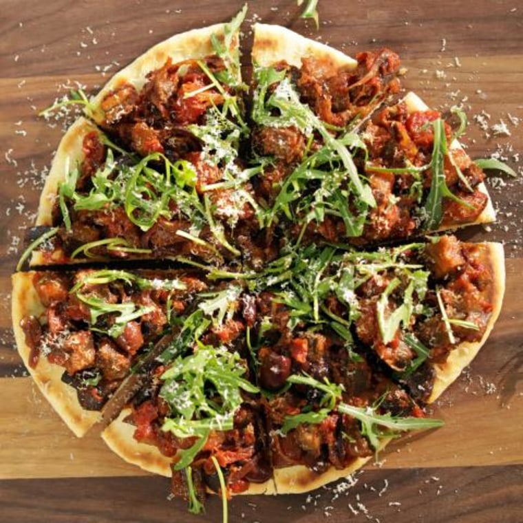 Above shot, caponata pizza on wooden chopping board, marble benchtop, as seen on Mary McCartney Serves It Up, season 3.