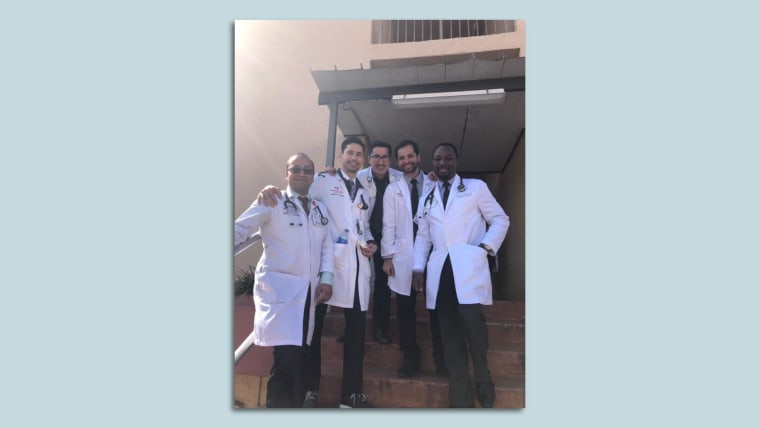 Cinco médicos hombres con batas sonríen a la cámara. Son parte de un equipo de fútbol de doctores en Florida