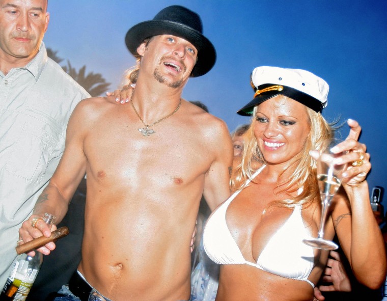 Pamela Anderson (R) shares a drink with her husband, US musician Kid Rock (C), the day of their wedding, on Pampelone's beach in Saint-Tropez, Southern France, 29 July 2006. Anderson, 39, married Rock, 35, aboard a yacht.