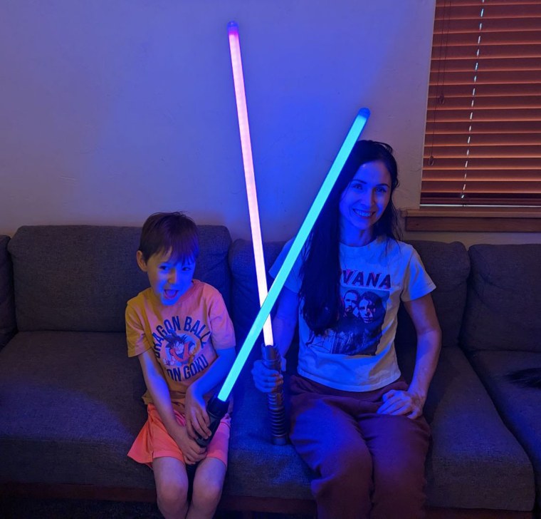 Casey Andrews and his son show off their lightsabers.  Andrews says his house is more into video games than sports, and he's happy with that.