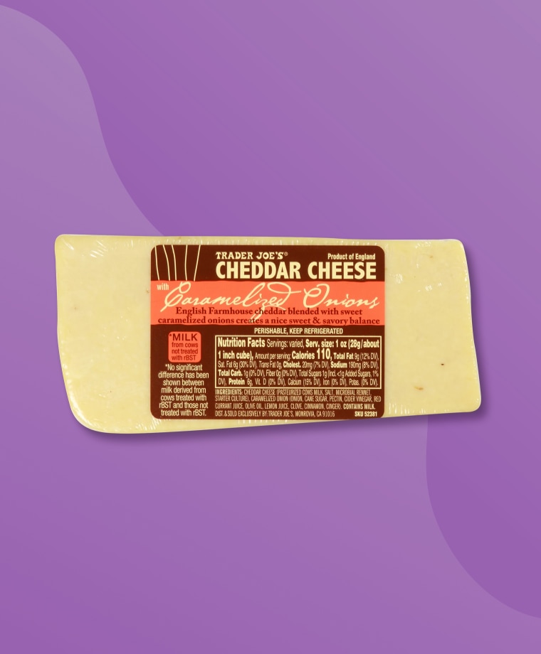 A wedge of Trader Joe's Cheddar Cheese with Caramelized Onions on a purple background.