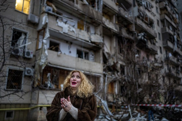 Natali Sevriukova reacciona al ver los edificios destruidos por un ataque aéreo en Kiev, Ucrania, el 25 de febrero de 2022. 