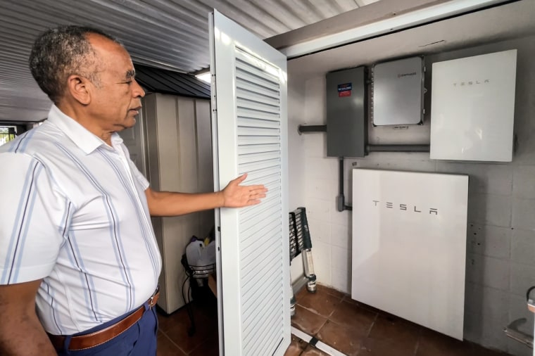 Víctor Santana shows the batteries attached to the solar panels.