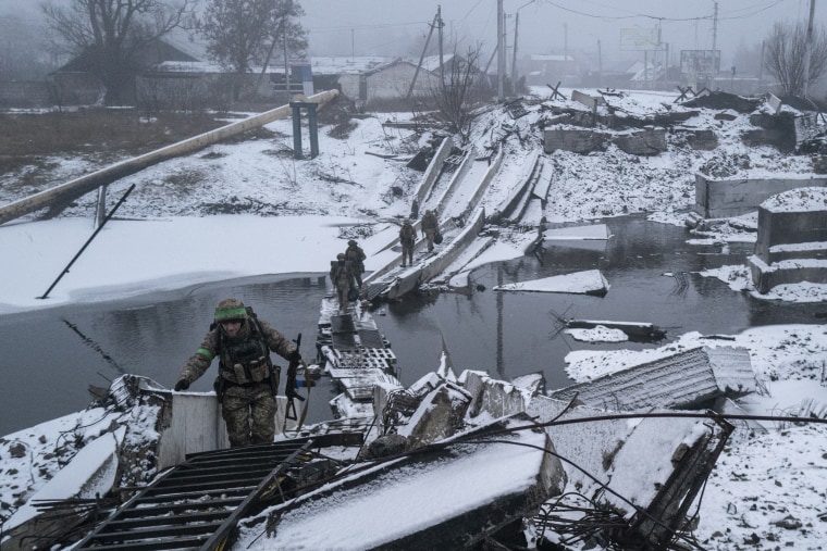  Ukrainian soldiers cross a destroyed bridge as they return from the front line in Bakhmut, Ukraine on Jan. 29, 2023. 