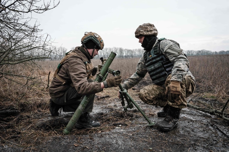 Ukrainian soldiers adjust a 60mm mortar tube near the frontline in the Donetsk region on Jan. 31, 2023. 