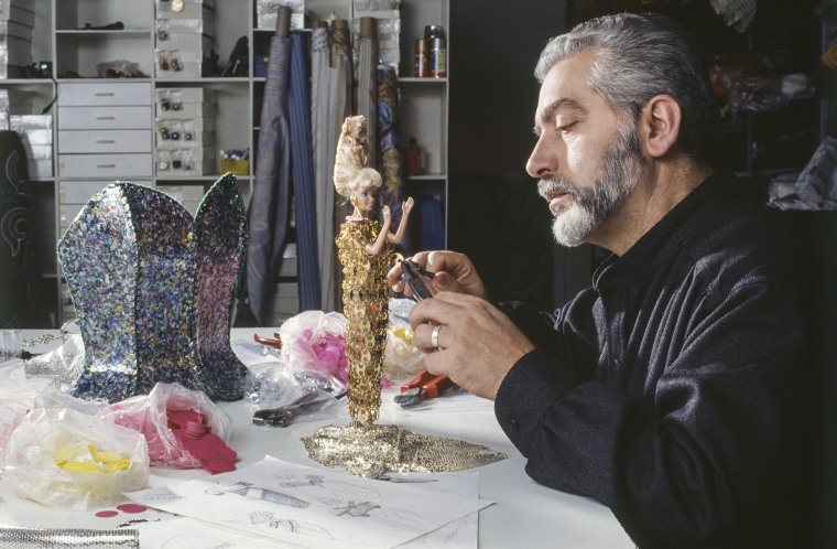 Paco Rabanne arregla un vestido a una muñeca Barbie en 1989.