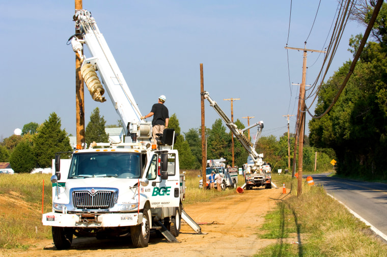 Baltimore Gas & Electric trucks hooking up power lines