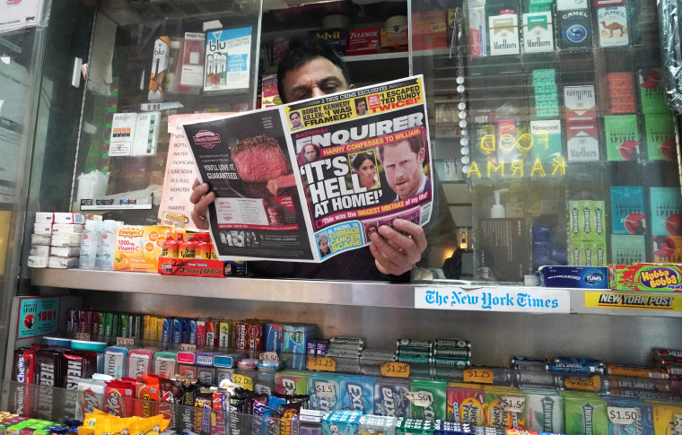 A newspaper vendor displays a copy of the National Enquirer at his newstand in New York
