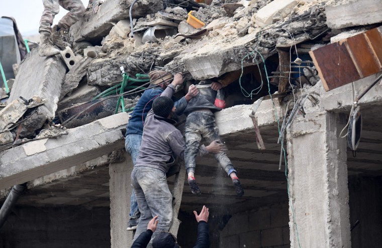 Residents retrieve an injured girl from the rubble of a collapsed building in Jandaris, Syria on Feb. 6, 2023.
