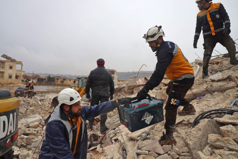 Members of Syria's "White Helmets" look for casualties under the rubble in Sarmada in Idlib province, early on Feb. 6, 2023. 